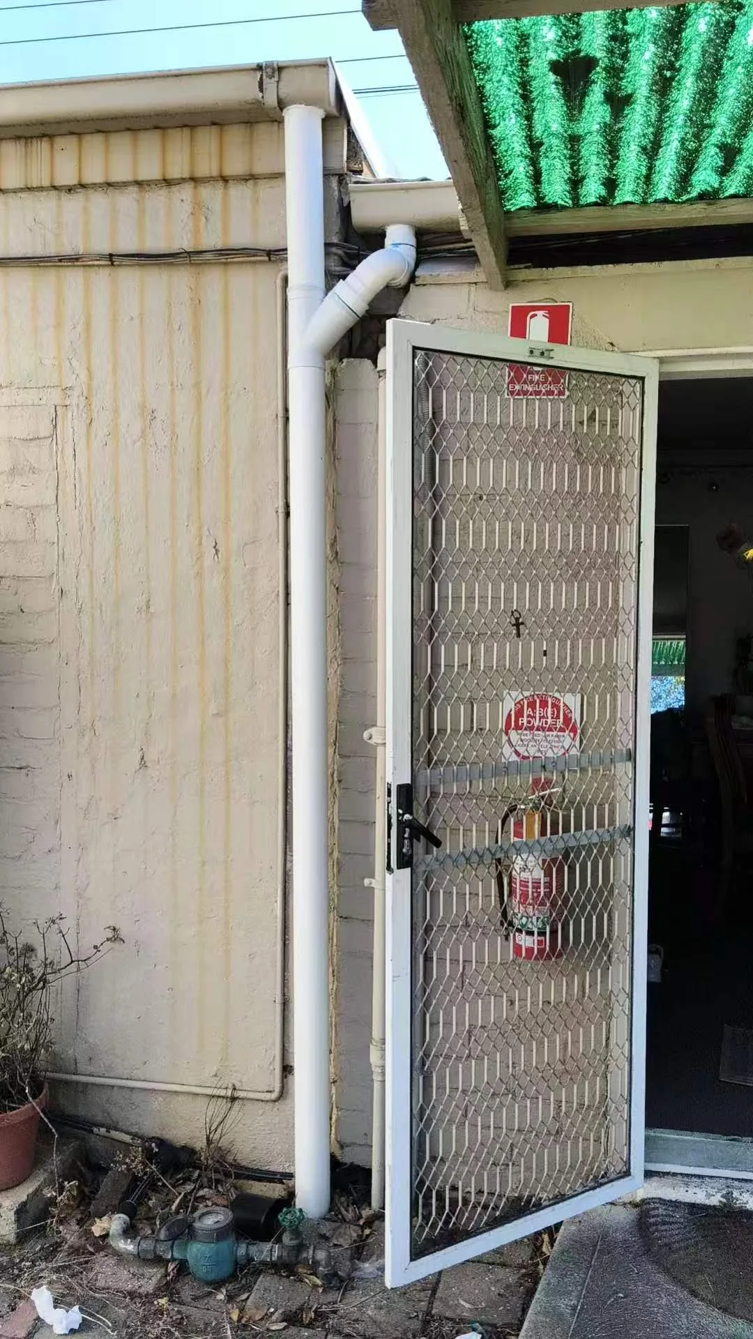 Full-height exterior drainage pipe installed beside a Brisbane property doorway